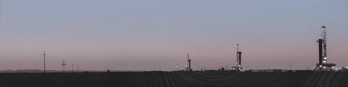 Devon Energy drilling rigs at a Permian Basin multi-well production pad