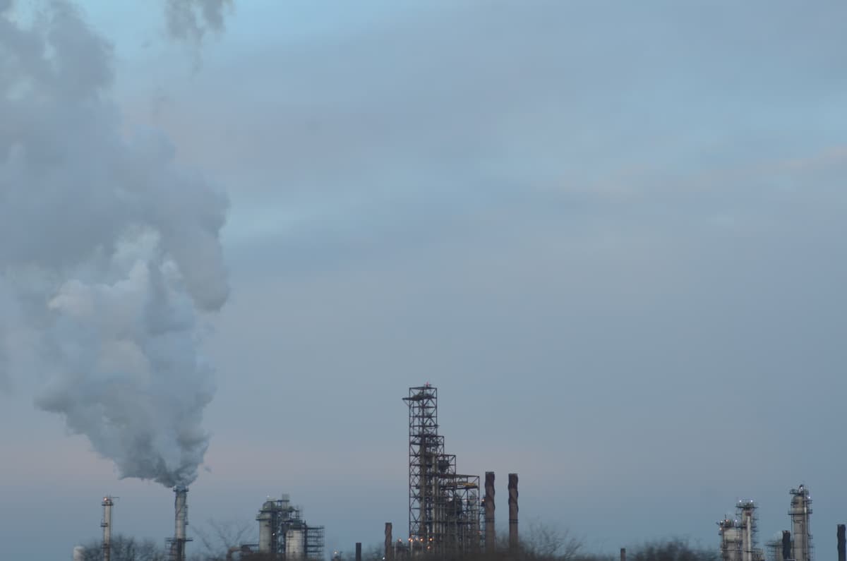 ExxonMobil oil refinery complex adjacent to Interstate 55 in Joliet, Illinois, with industrial towers and flaring visible