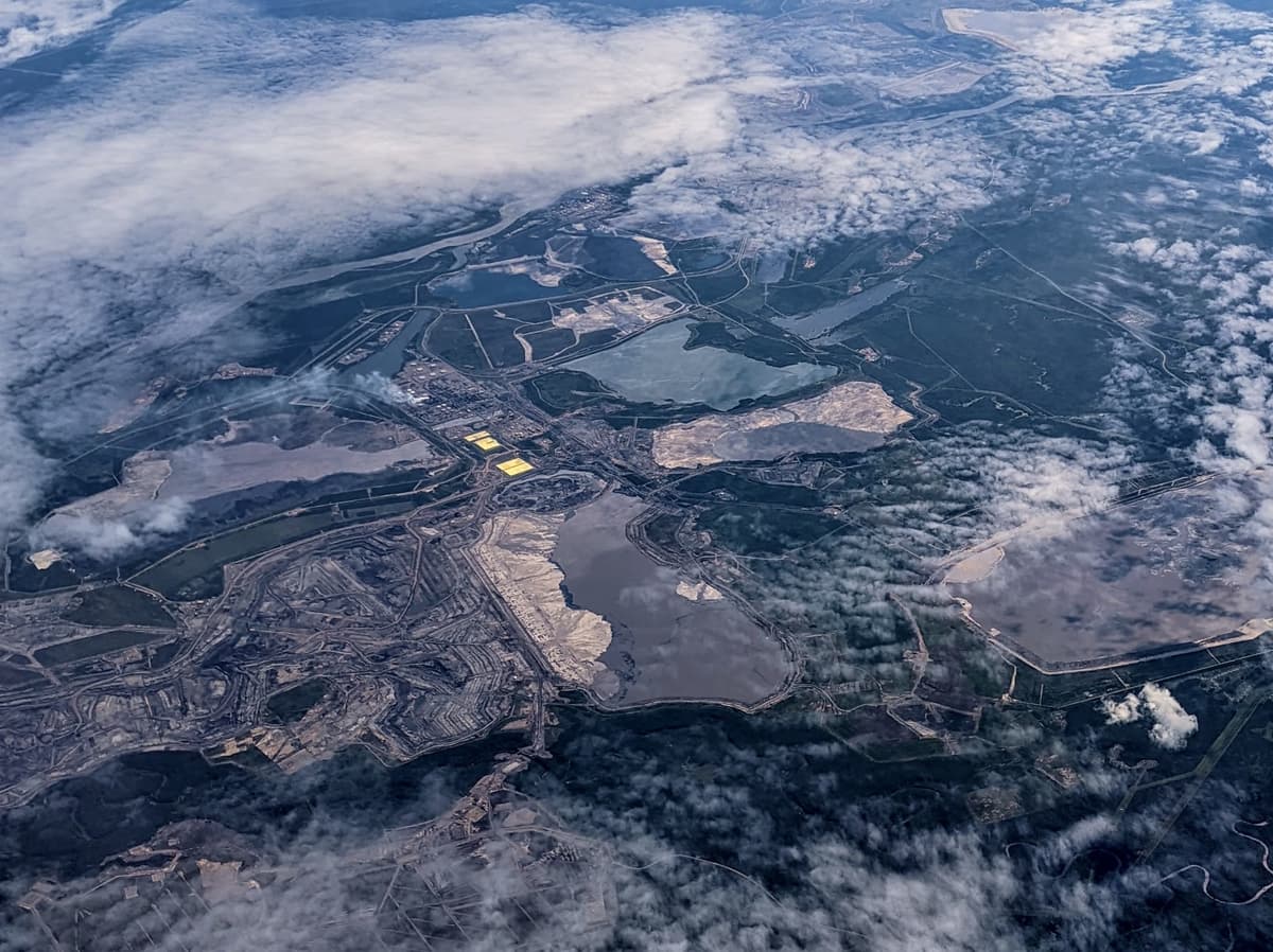 Aerial view of Syncrude Mildred Lake oil sands mining facility with tailings dam and sulfur stockpiles in Alberta