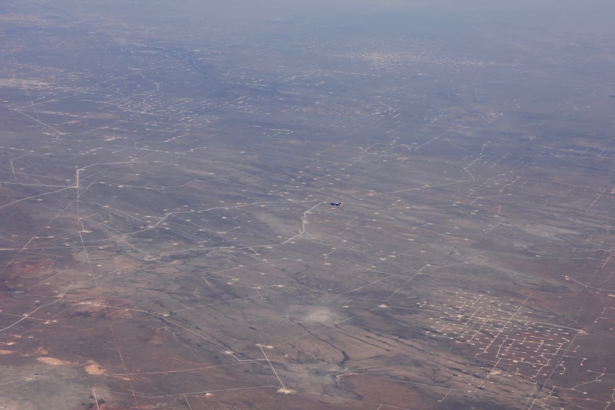 Aerial view of oil extraction facilities and pumpjacks across a Texas oilfield