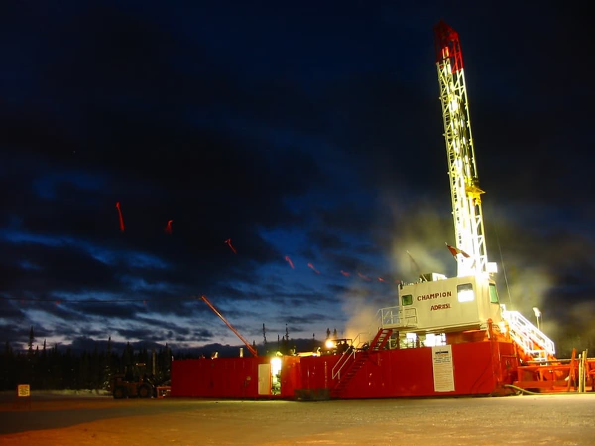 Oil drilling rig in northern British Columbia Canada amid boreal forest and remote terrain