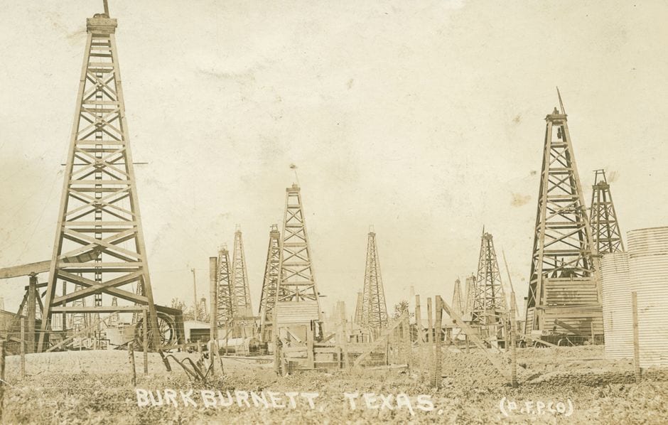 Sepia postcard photograph of wooden oil derricks crowding the boom town of Burkburnett, Texas in 1919