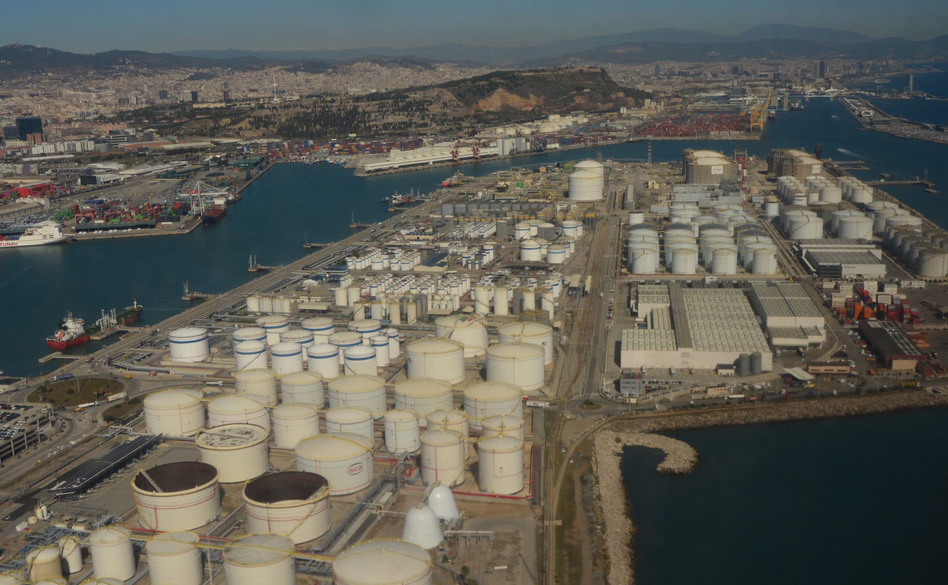 Aerial photograph of large cylindrical petroleum storage tanks at the Port of Barcelona, Spain