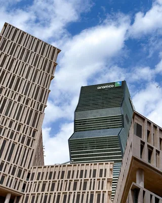 Saudi Aramco corporate headquarters tower in Dhahran with desert landscape and clear sky