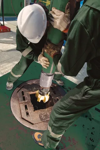 Baker Hughes field workers operating on a drilling floor rig at a North American shale wellsite