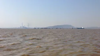 Mumbai oil refinery viewed from Bombay Harbor with oil tanker approaching facility
