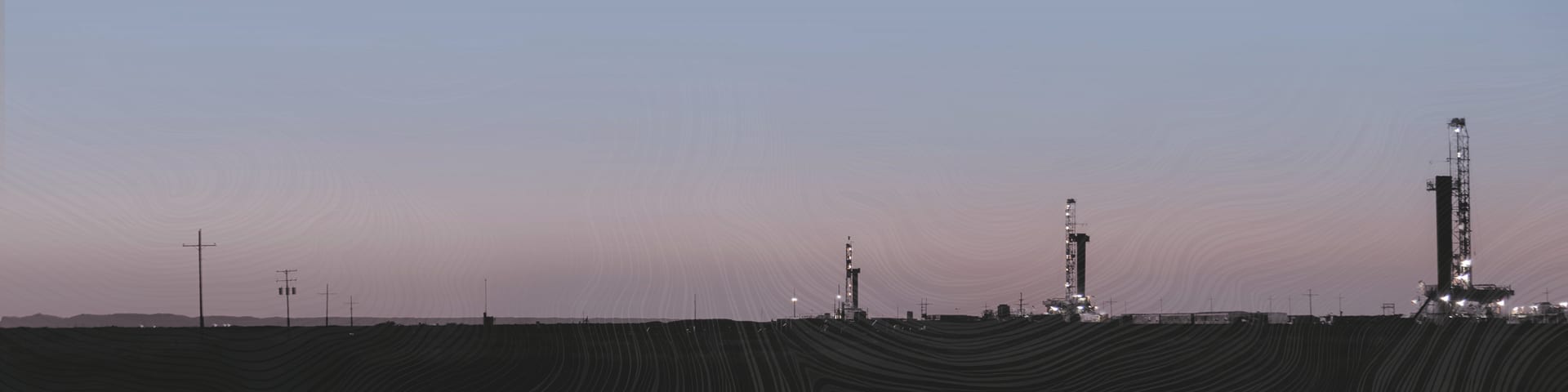 Devon Energy drilling rigs at a Permian Basin multi-well production pad