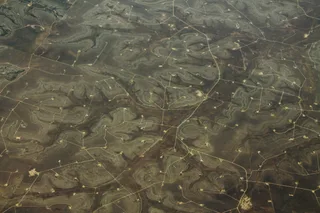 Aerial view of oil drilling pads and access roads across the Permian Basin near Sterling City, Texas