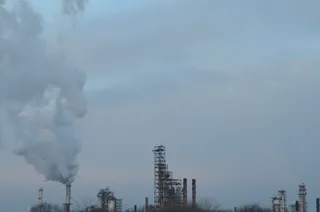 ExxonMobil oil refinery complex adjacent to Interstate 55 in Joliet, Illinois, with industrial towers and flaring visible