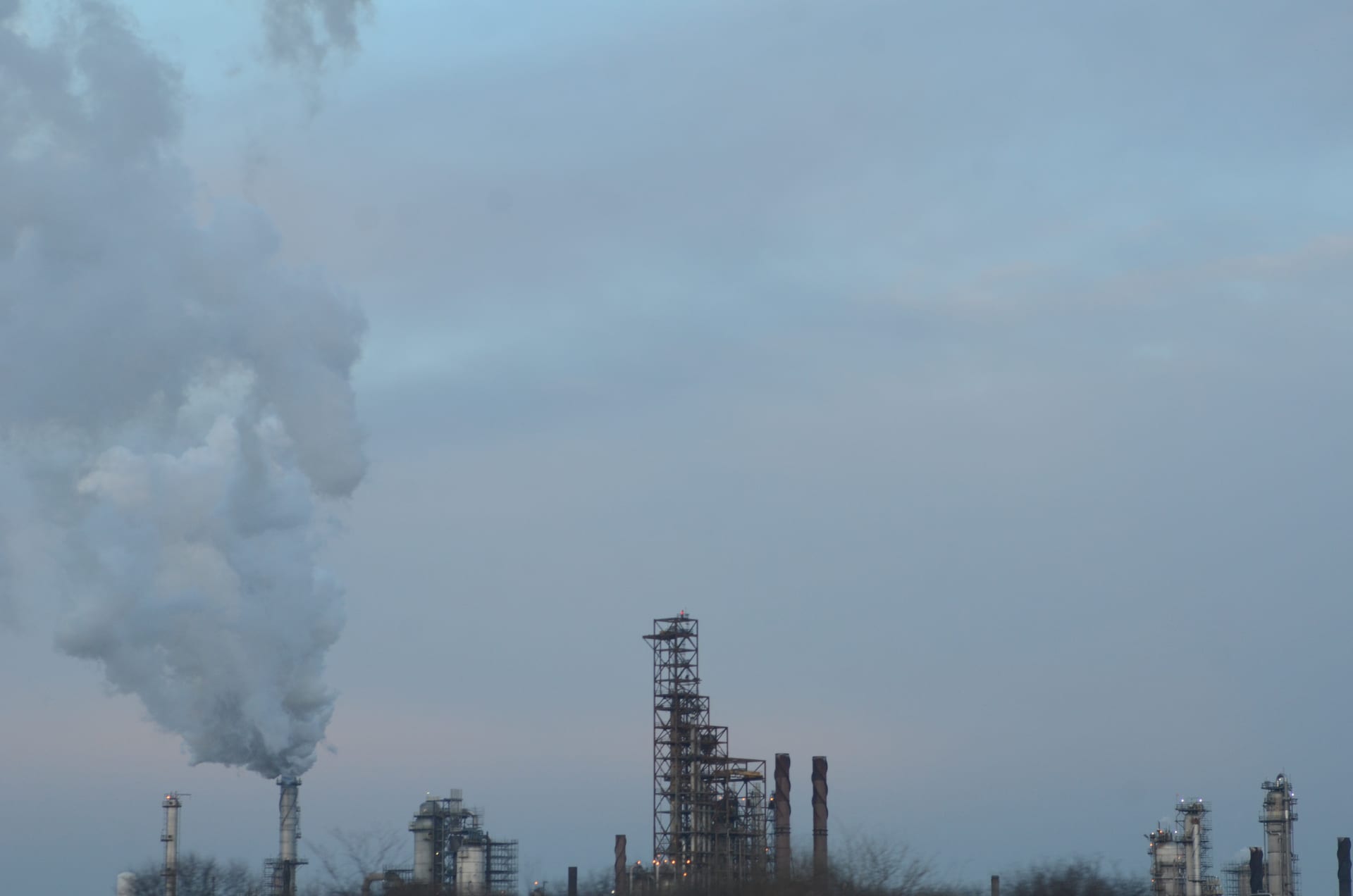 ExxonMobil oil refinery complex adjacent to Interstate 55 in Joliet, Illinois, with industrial towers and flaring visible