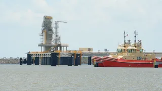 LNG loading arms and tugboats at Golden Pass terminal at Sabine Pass, Texas, awaiting LNG tankers