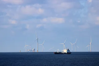 Oil tanker steaming through the North Sea past an offshore wind farm on a calm afternoon