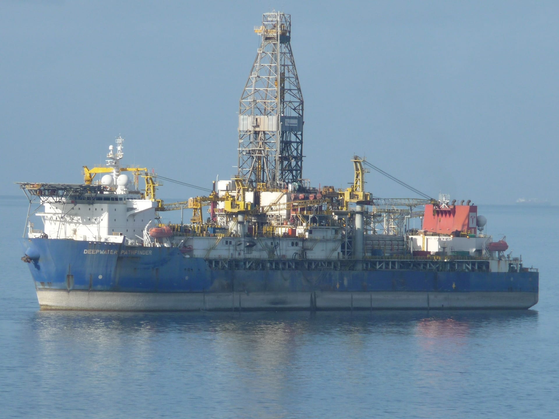 Transocean Deepwater Pathfinder drillship at sea in daylight with drill derrick visible