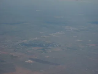 Permian Basin oil and gas infrastructure across the West Texas plain showing wellsite tanks pumpjacks
