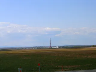 Industrial natural gas processing plant in Alberta with metal storage tanks pipework and fractionation towers under blue sky