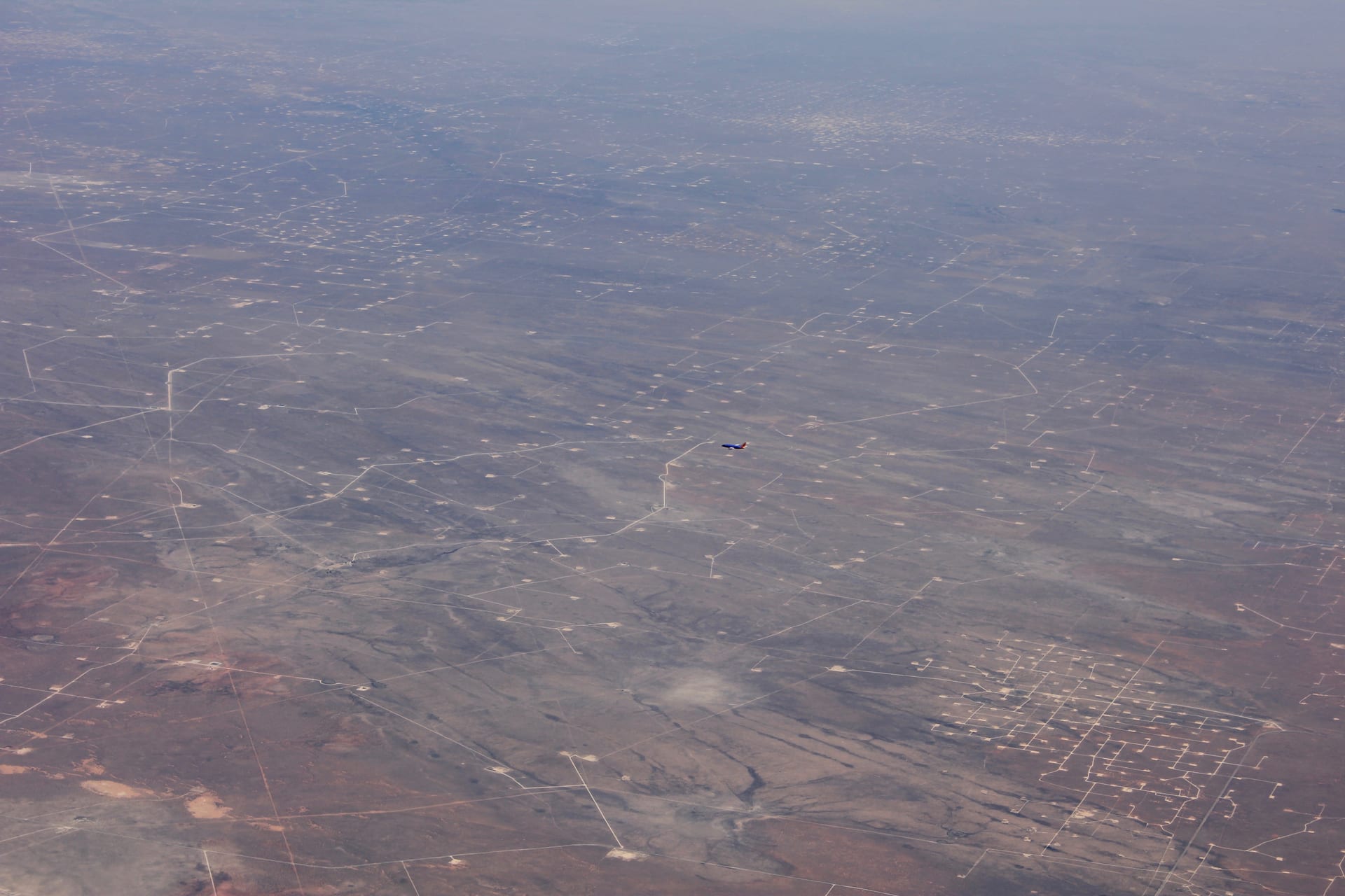 Aerial view of oil extraction facilities and pumpjacks across a Texas oilfield